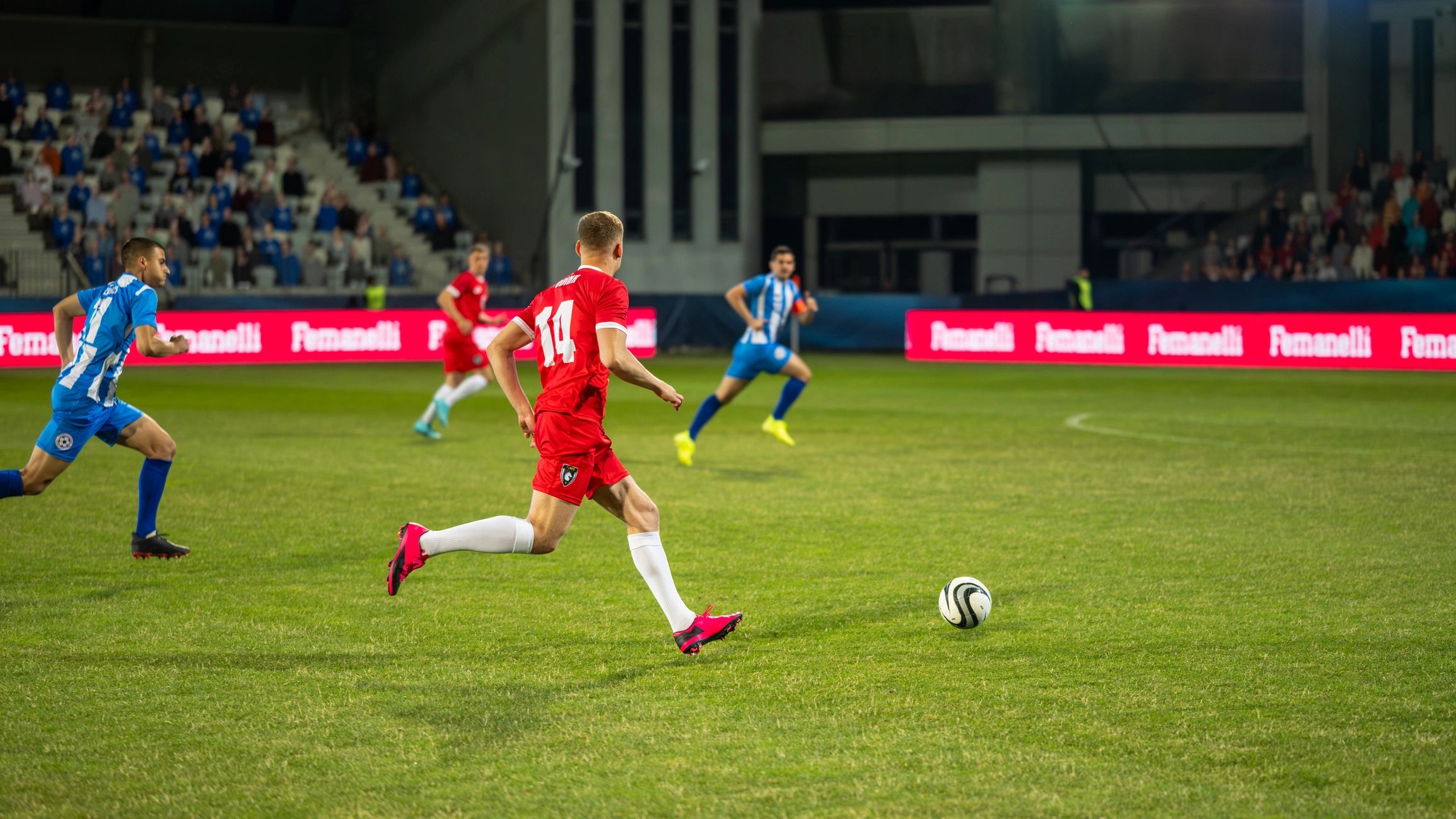 Futbolistas compitiendo en un estadio profesional